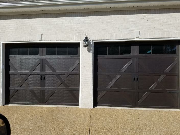 Pair of dark brown carriage garage doors with X-brace panels and top windows