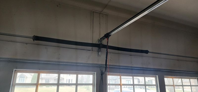 Torsion spring and opener rail on the header above a garage door with windows